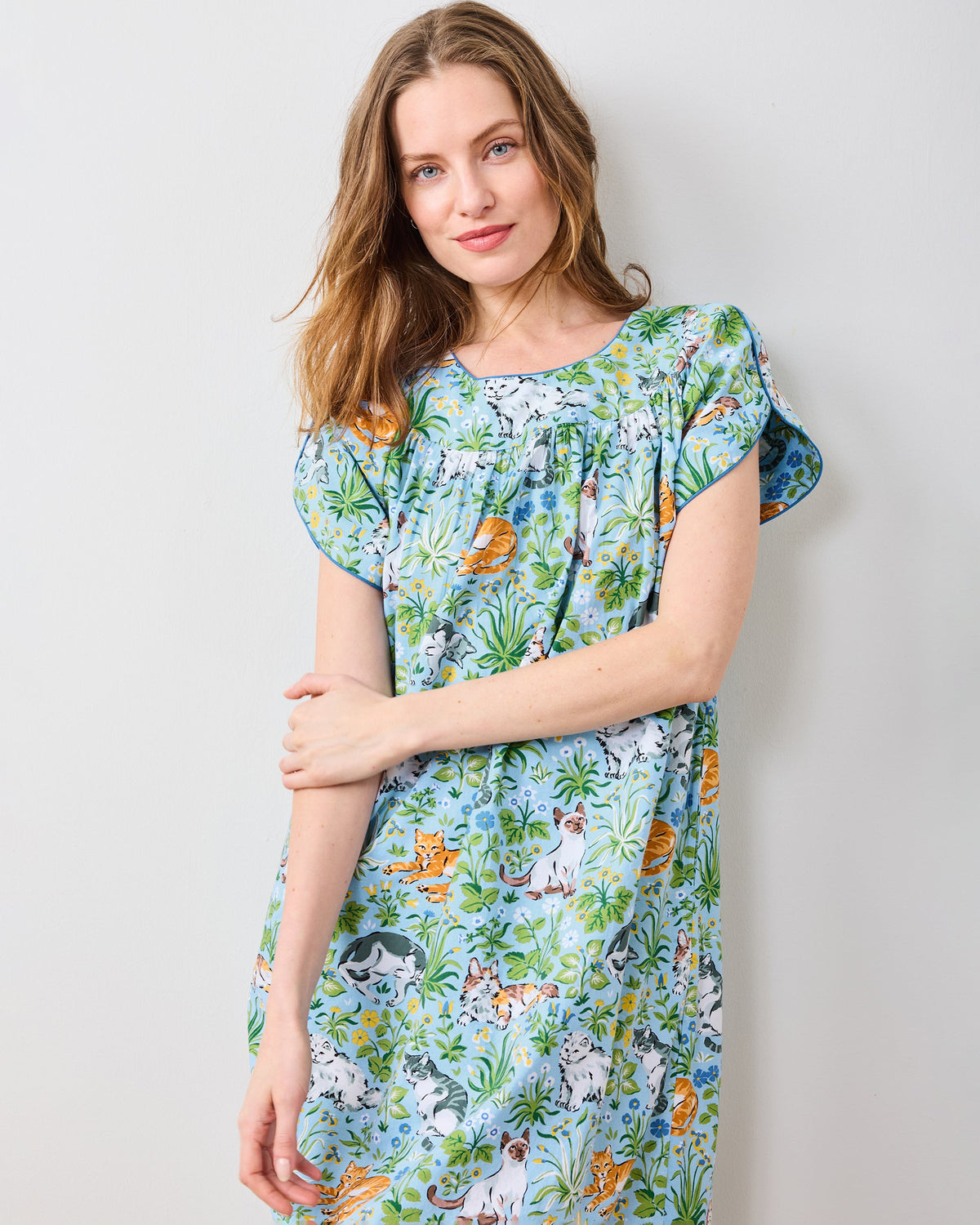 Close-up front view of the Retro Dreams nightgown in a light blue cat-and-floral print, showing the rounded gathered neckline and short sleeves.