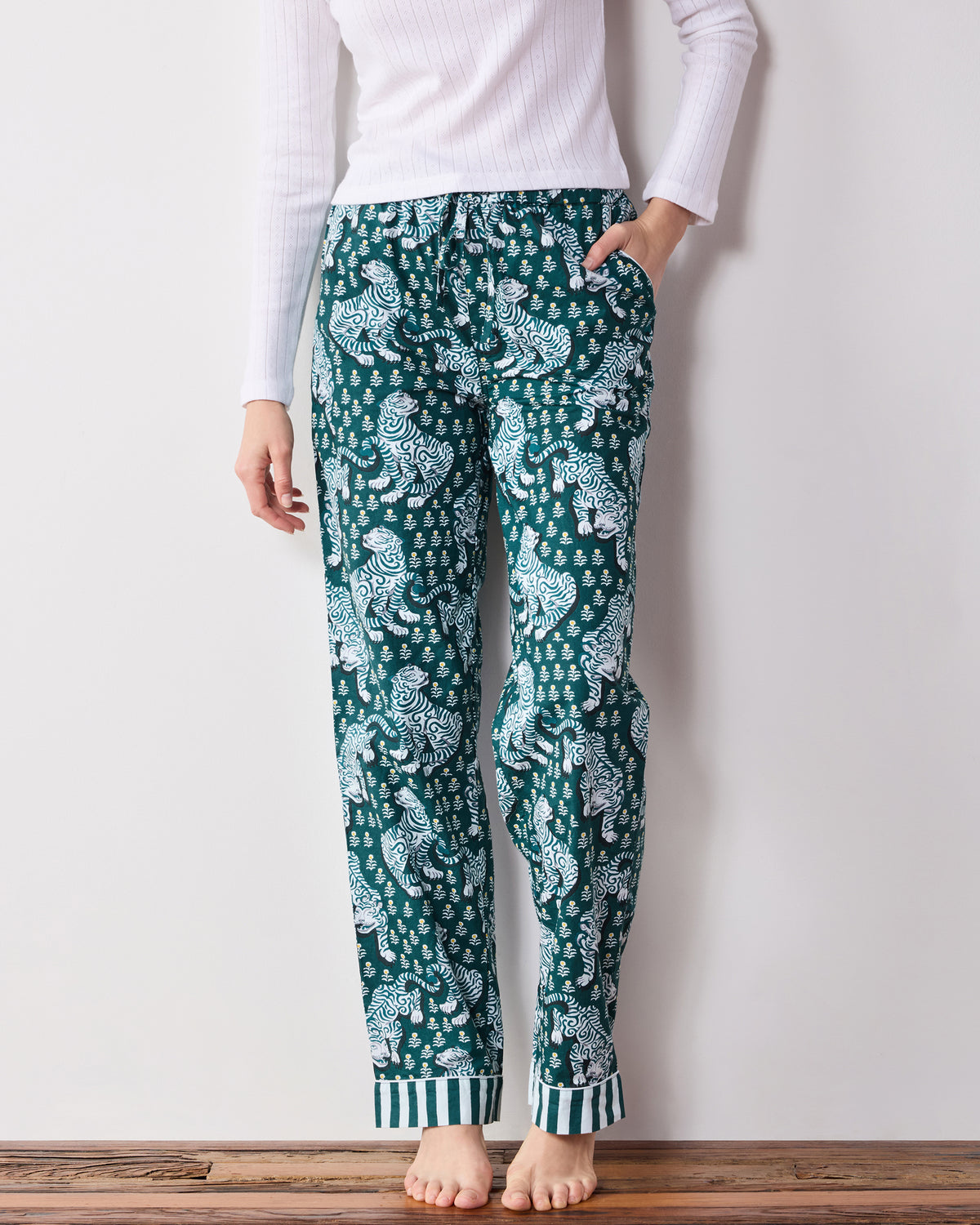 Front view of Game Day Green Tiger Queen pajama pants with tiger print, drawstring waistband, side pockets, and striped cuffs.