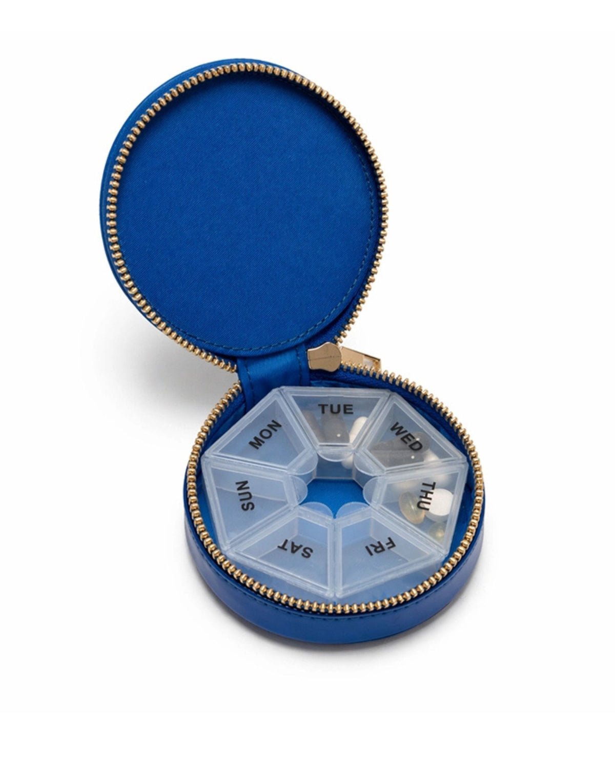 Open blue Caviar Daily Pill Case containing a seven-compartment organizer labeled for each day of the week.