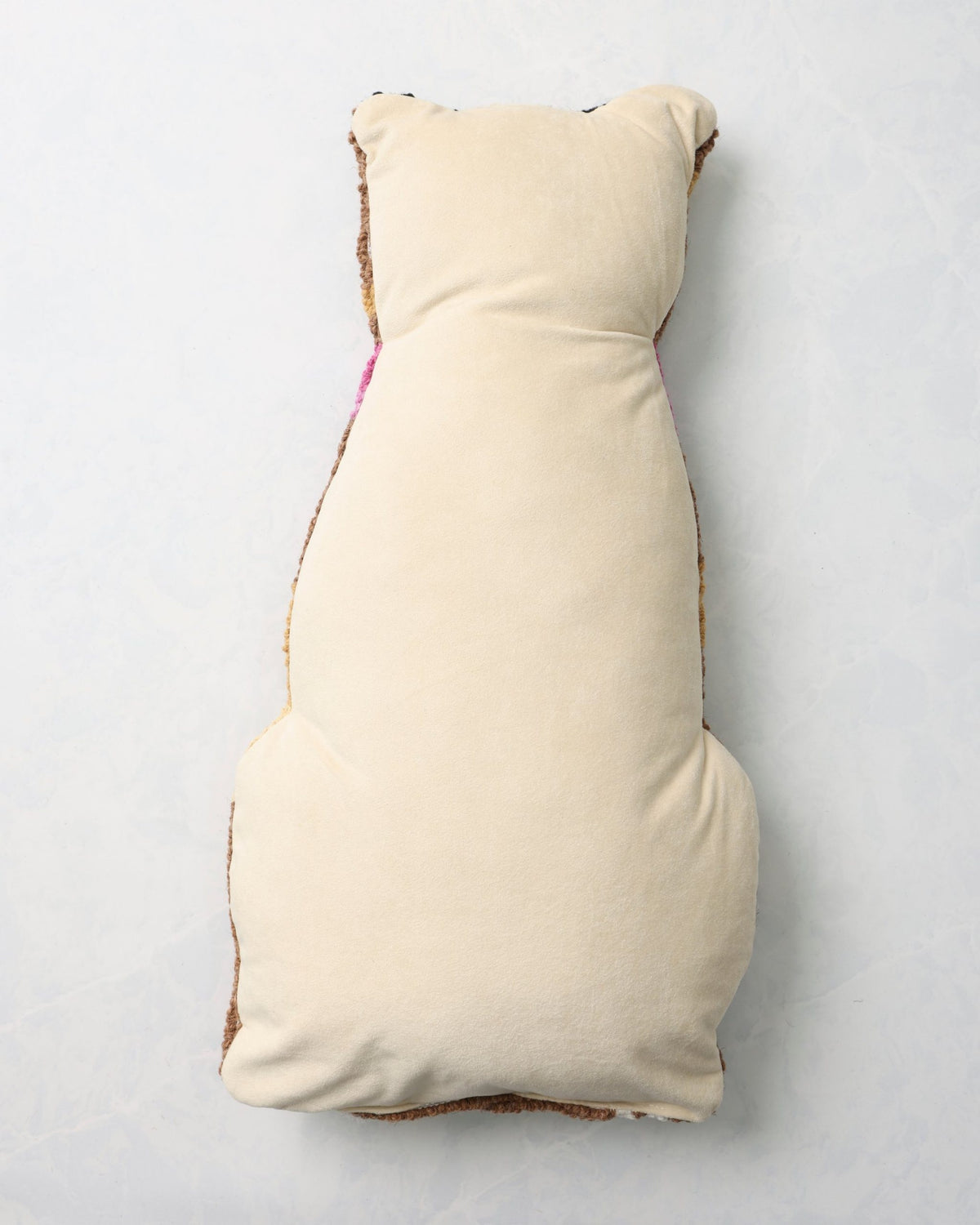 Back of the leopard pillow with a plain light-colored backing.