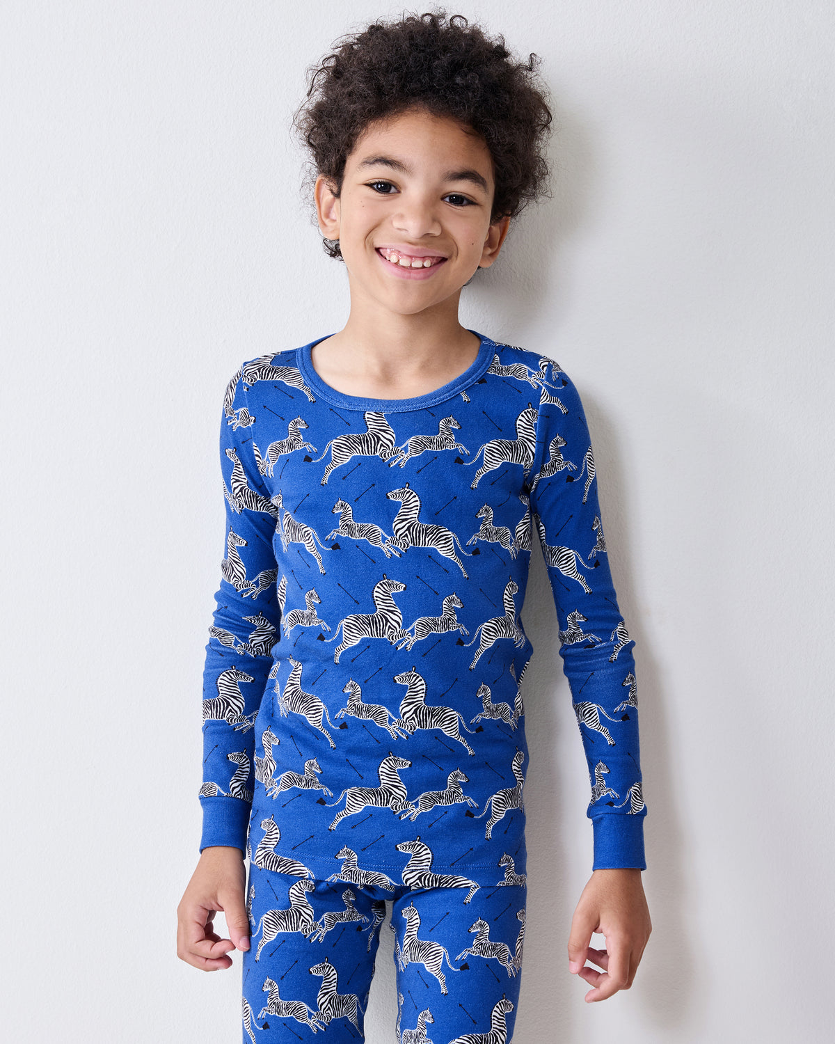 Close view of a model wearing the blue long-sleeve pajama top with a zebra-and-arrow print.