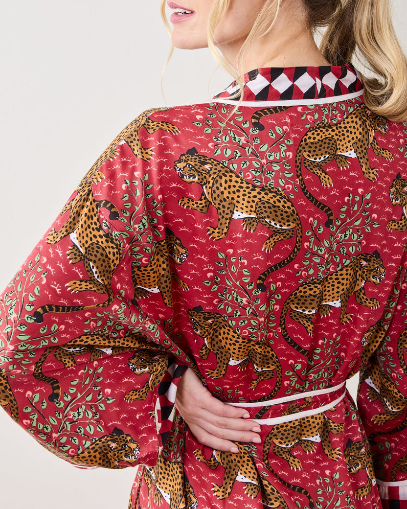 Back view of a person wearing the scarlet Bagheera robe, showing the leopard print, leafy pattern, white piping, and geometric collar trim.
