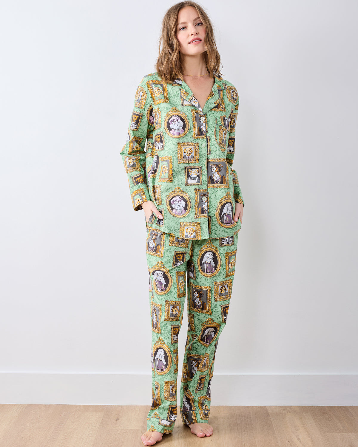 Model wearing a green long pajama set with framed dog portrait print, button-down top, and matching pants.