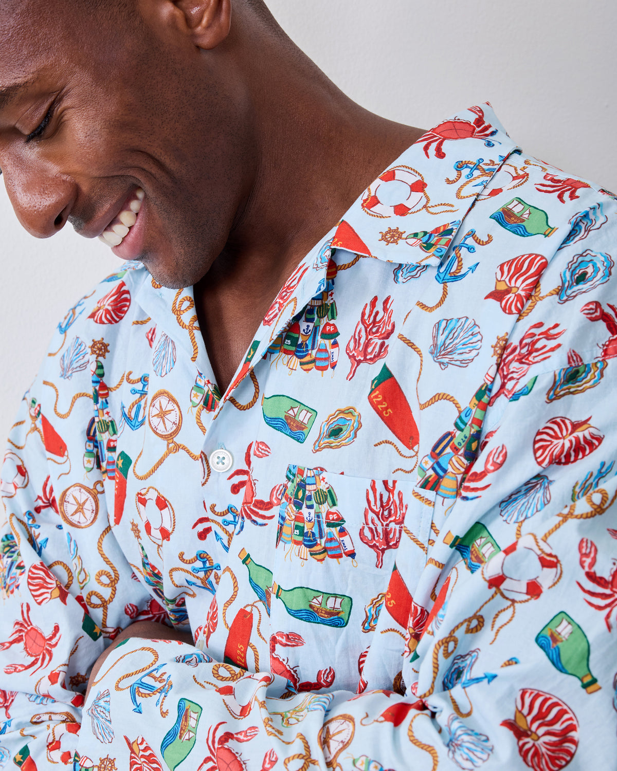 Close-up of the men's Holidays Ahoy pajama top showing the collar, chest pocket, buttons, and nautical holiday print.