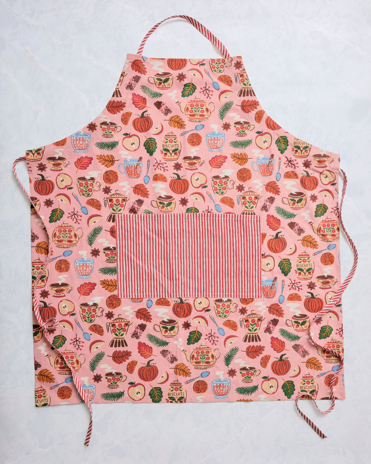 Rose-pink autumn print apron with striped neck strap, waist ties, and a large striped front pocket.