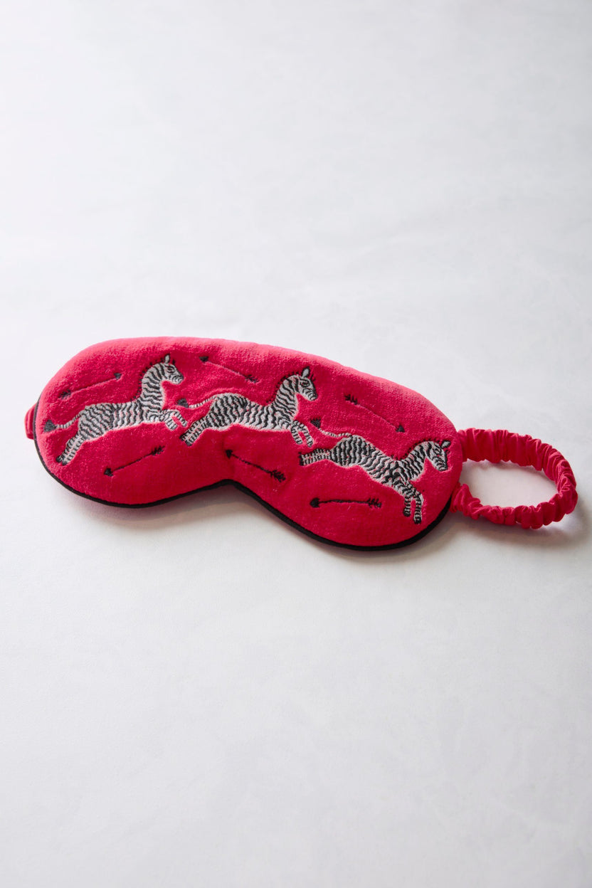 Red embroidered velvet eye mask with zebra motifs and an elastic band, shown flat.