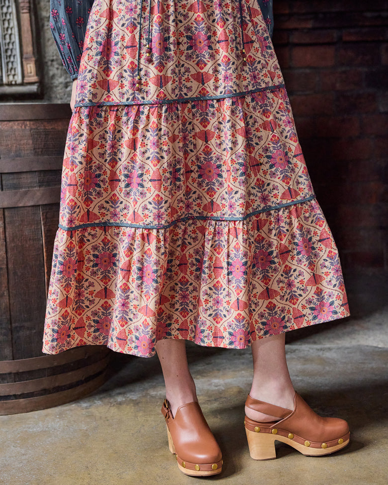 Detail view of the Eden Dress tiered floral-print skirt and brown platform shoes.