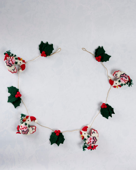 Holiday hens garland arranged in a circle, with four felt hens in Santa hats alternating with holly leaves and red berries.