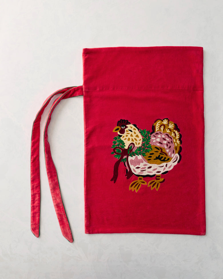 Flat view of a red gift sack with an embroidered hen carrying greenery and a bow, plus two ties.