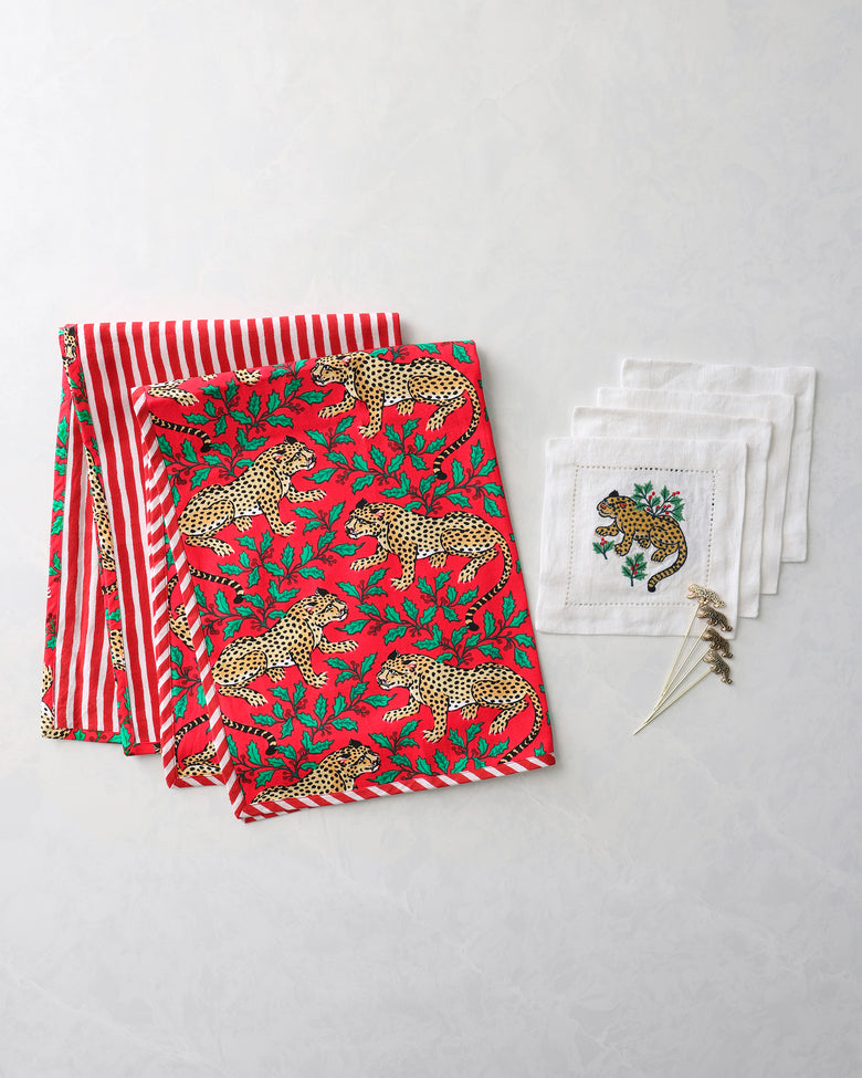 Cocktail bundle with two leopard-print tea towels, four white embroidered napkins, and four leopard cocktail picks.
