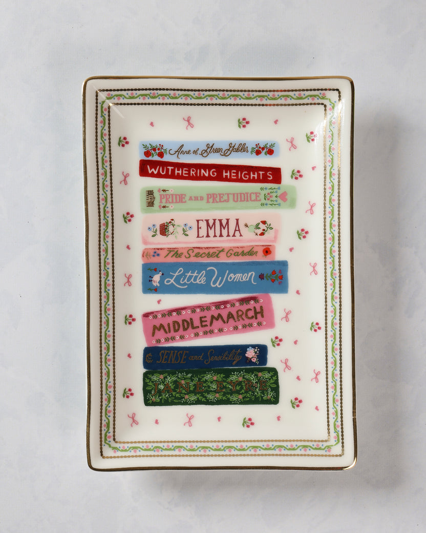 Rectangular porcelain catchall tray decorated with colorful book spines, including Anne of Green Gables, Wuthering Heights, Pride and Prejudice, Emma, The Secret Garden, Little Women, Middlemarch, Sense and Sensibility, and Jane Eyre.