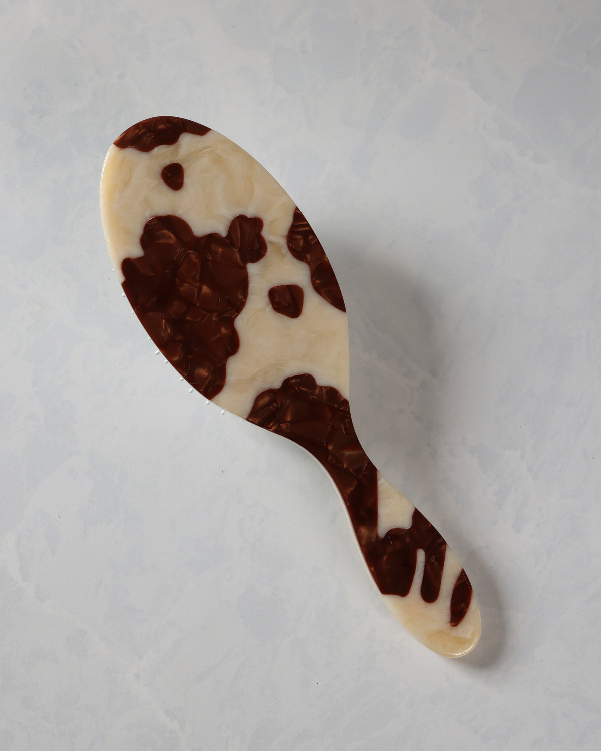 Hand-painted hair brush with an irregular brown-and-cream spotted pattern on the handle and brush body.