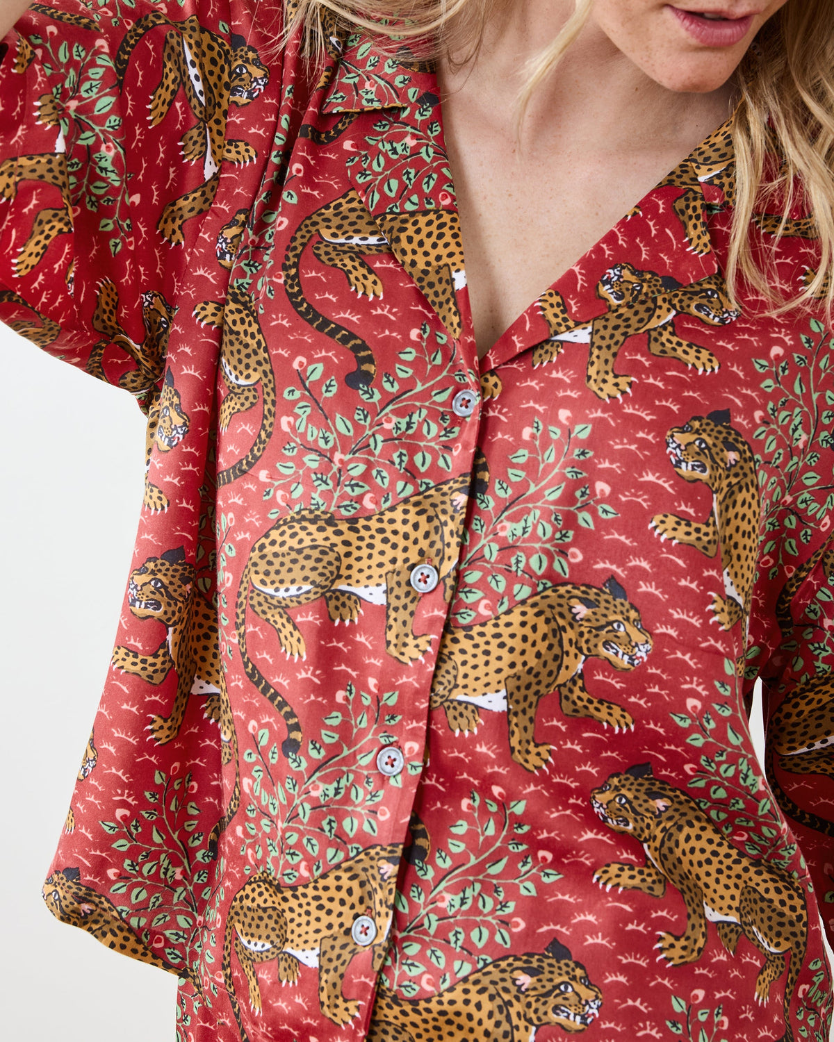 Close view of the scarlet Bagheera pajama top, showing its collar, button front, and leopard-and-leaf print.