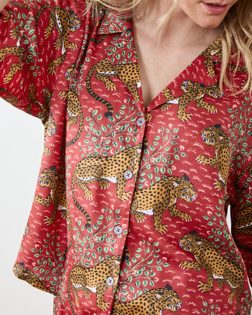 Close view of the scarlet Bagheera pajama top, showing its collar, button front, and leopard-and-leaf print.