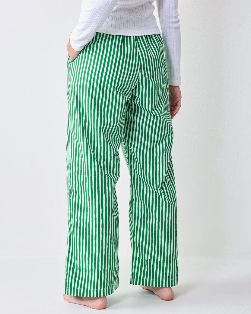 Back view of green-and-white vertically striped pajama pants with wide legs and side pockets.