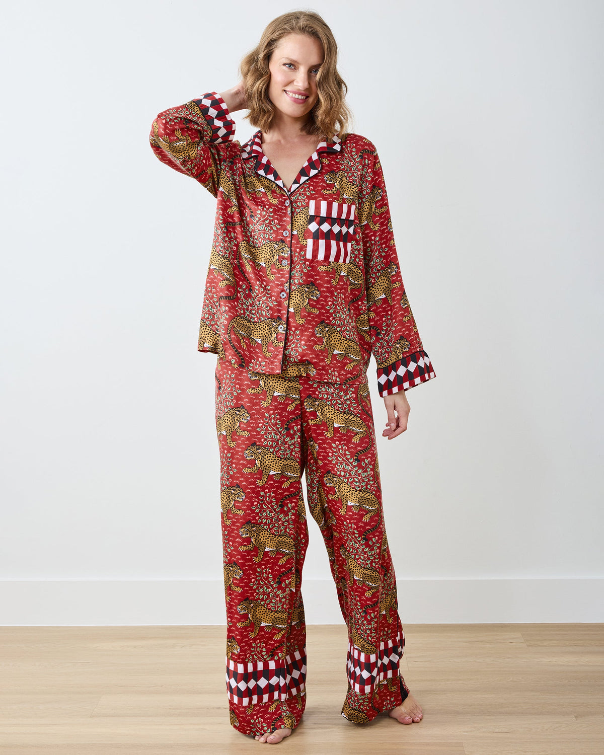 Full-length front view of a model wearing a red leopard-print pajama shirt and wide-leg pants with checkerboard trim.