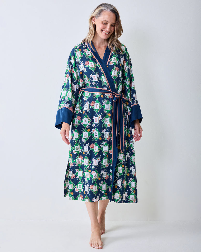 Full-length front view of the wintergreen Mahj Garden robe with dark blue trim, pink waist ties, wide cuffs, and floral patterned labels.