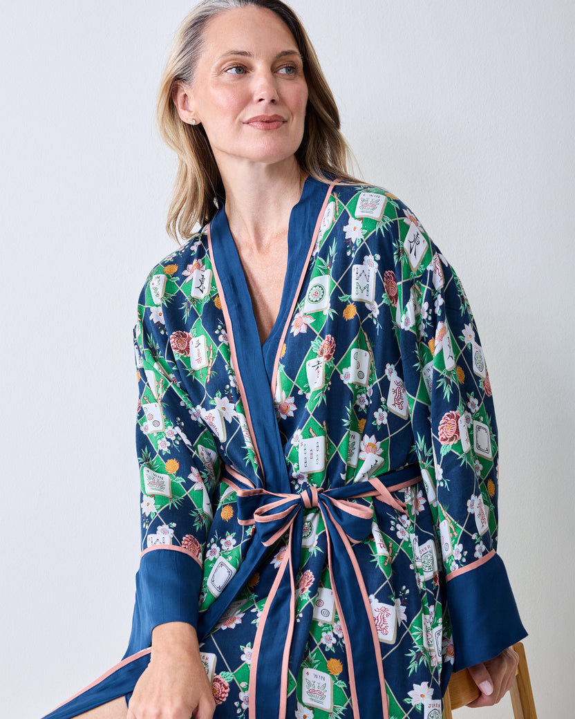 Close front view of the wintergreen Mahj Garden robe showing the dark blue trim, pink waist tie, and floral label pattern.
