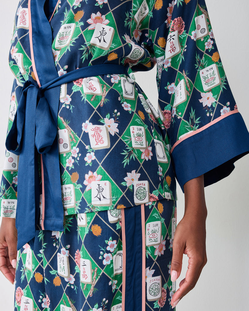 Close-up of the Mahj Garden Eco Satin Wrap Set in Wintergreen, showing the tied wrap front, blue cuff, pink trim, and floral mahjong-tile print.