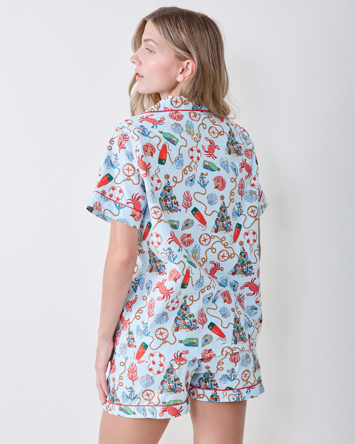 Back view of a person wearing a light blue nautical-print short pajama set.