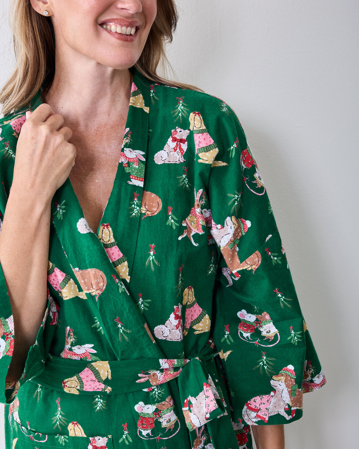 Close view of the green Mistletoe Kiss robe showing the wrap front, holiday critter print, matching belt, and sleeve detail.
