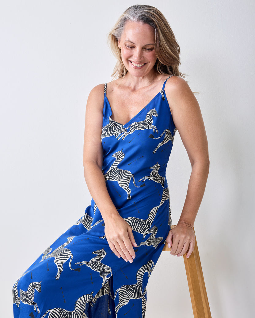 Seated view of a denim-blue zebra-print nightie with thin shoulder straps.