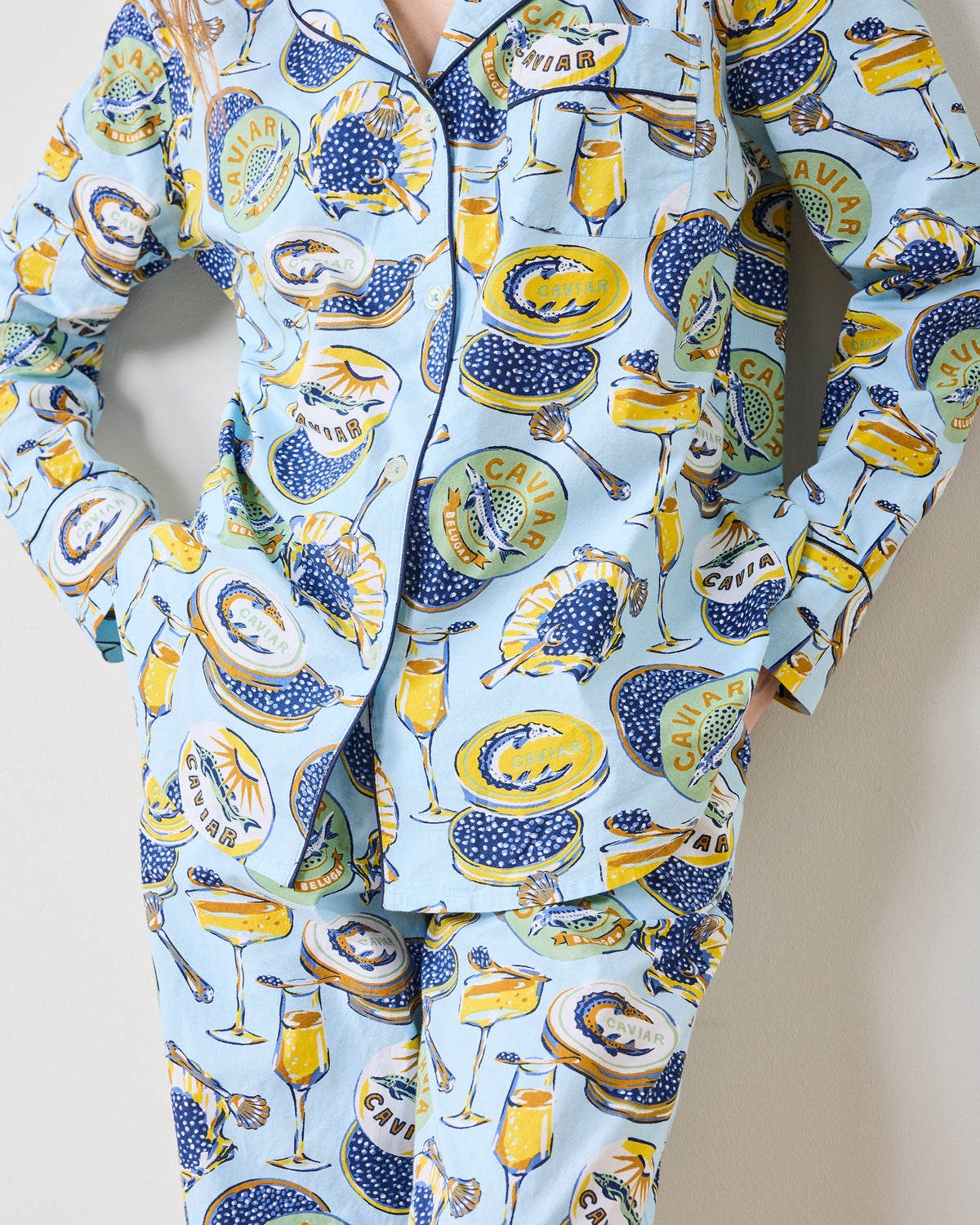 Close-up of the patterned button-front pajama top and matching pants, showing the collar, buttons, and caviar-themed print.