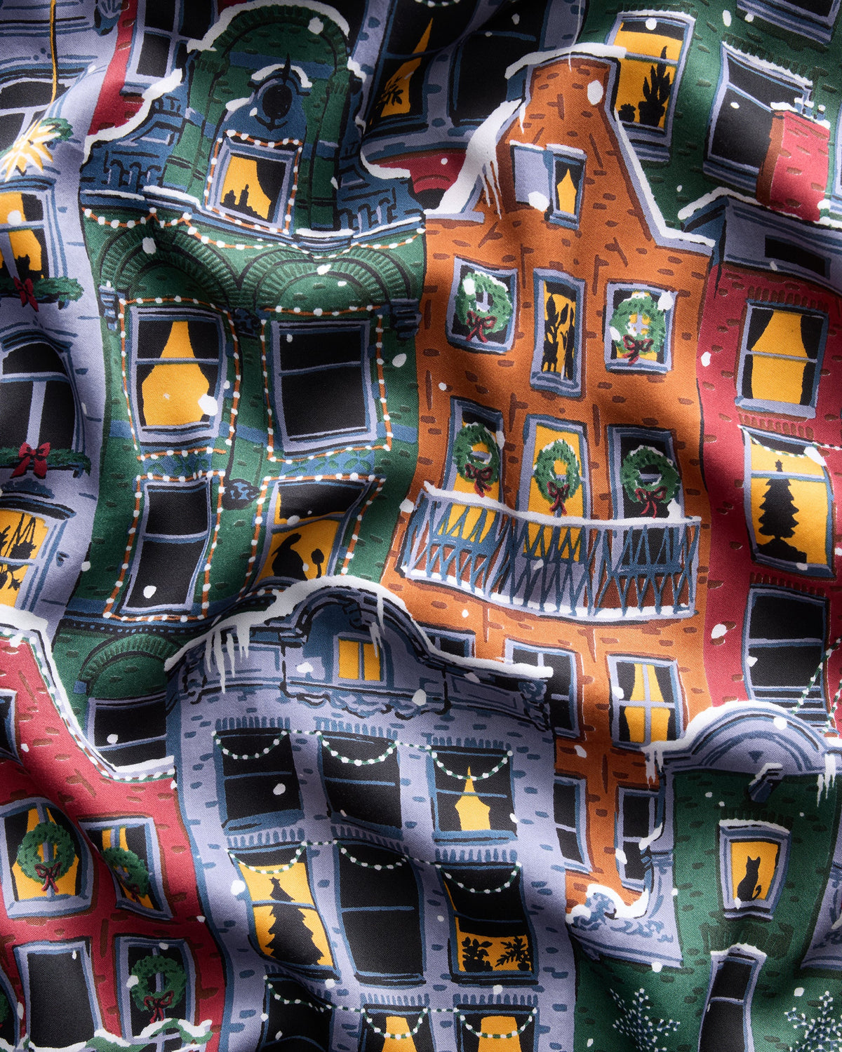 Close-up of the set’s colorful Christmas brownstone-building print, showing decorated windows, wreaths, trees, and snow.