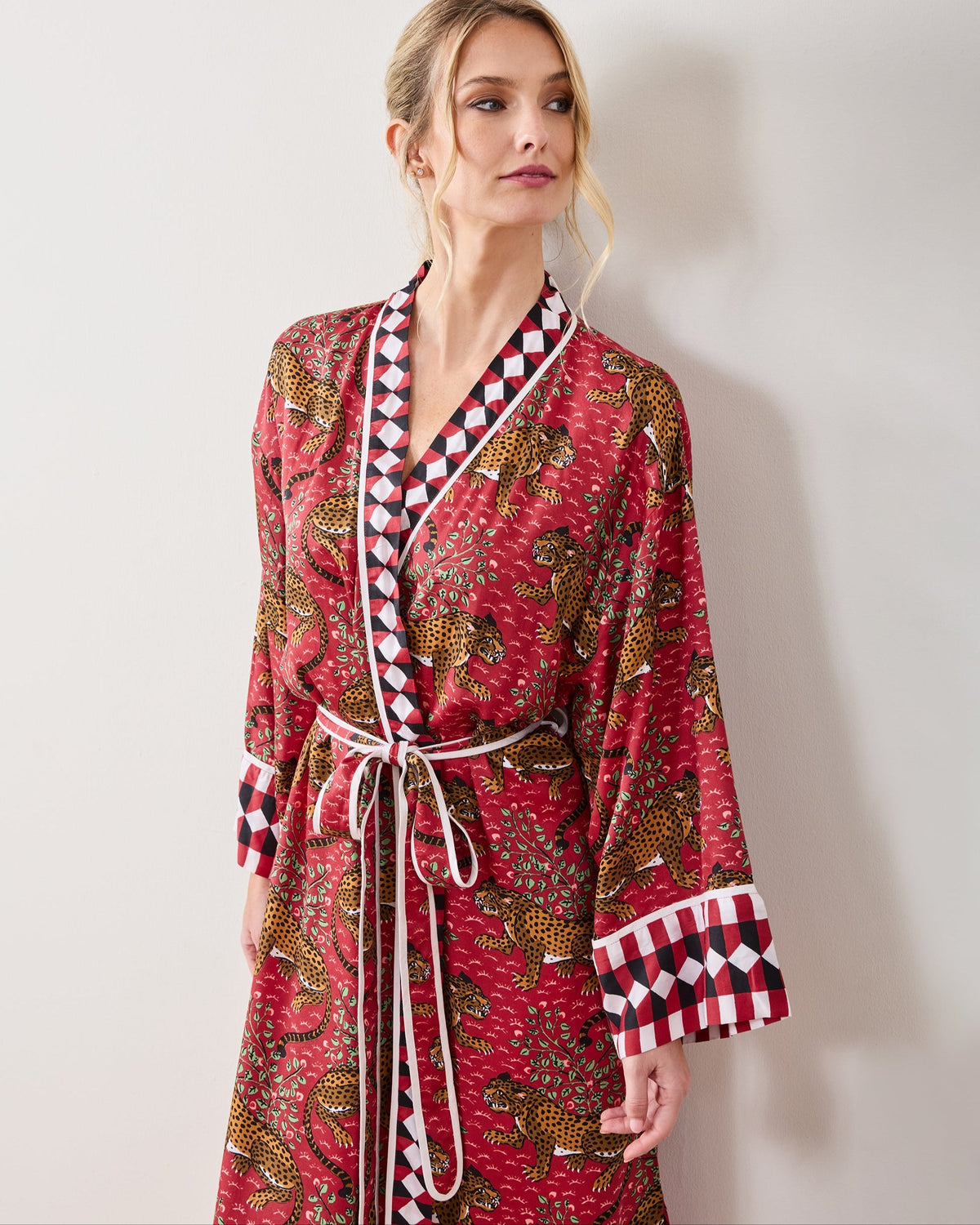 Front view of a person wearing the scarlet Bagheera robe with leopard print, geometric trim, and a tie belt.