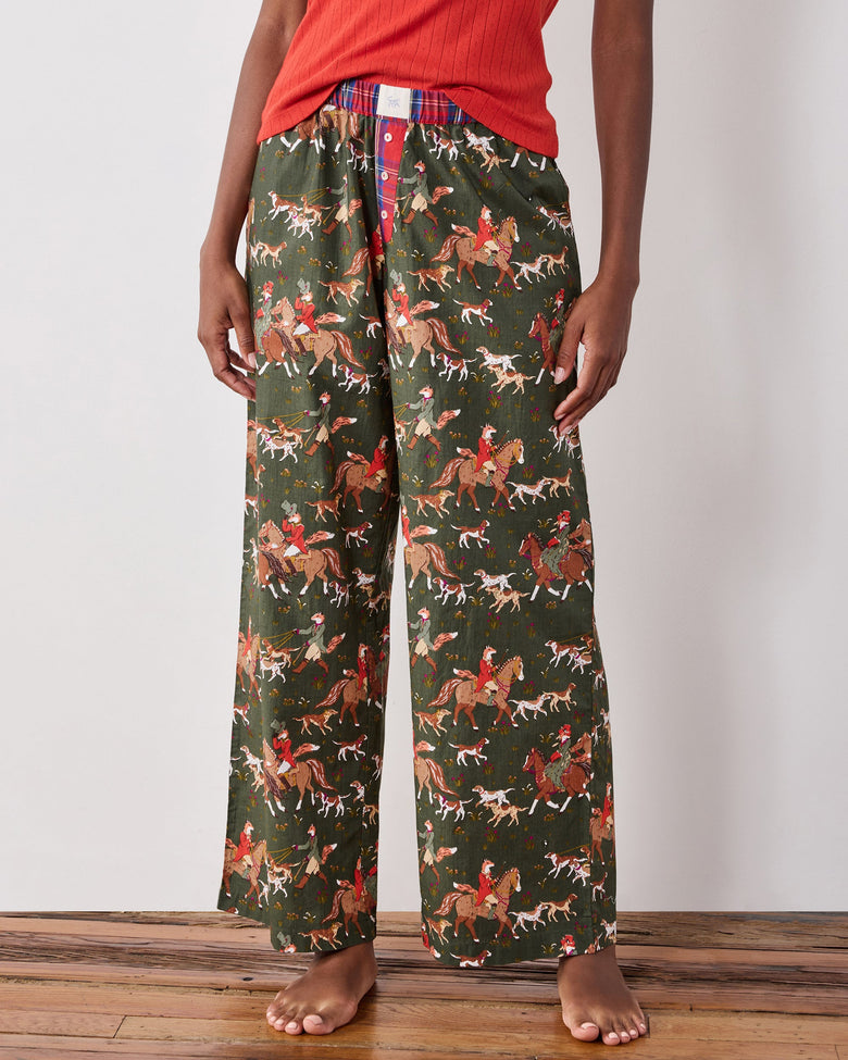 Front view of tall wide-leg pajama pants with a fox-and-hounds riding print, contrasting plaid waistband, and button fly.