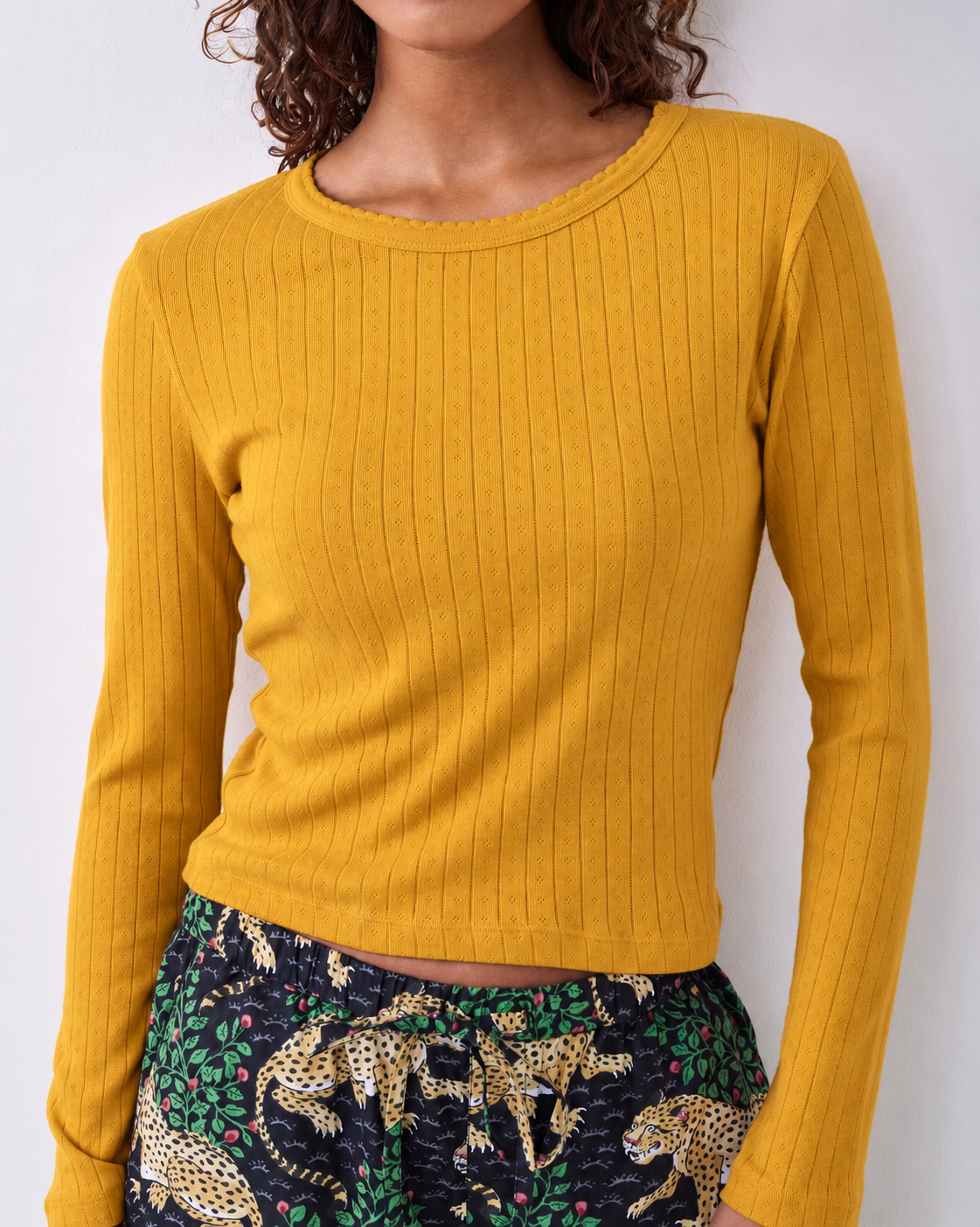 Goldenrod pointelle long-sleeve top with a scalloped neckline, worn with patterned pajama pants.