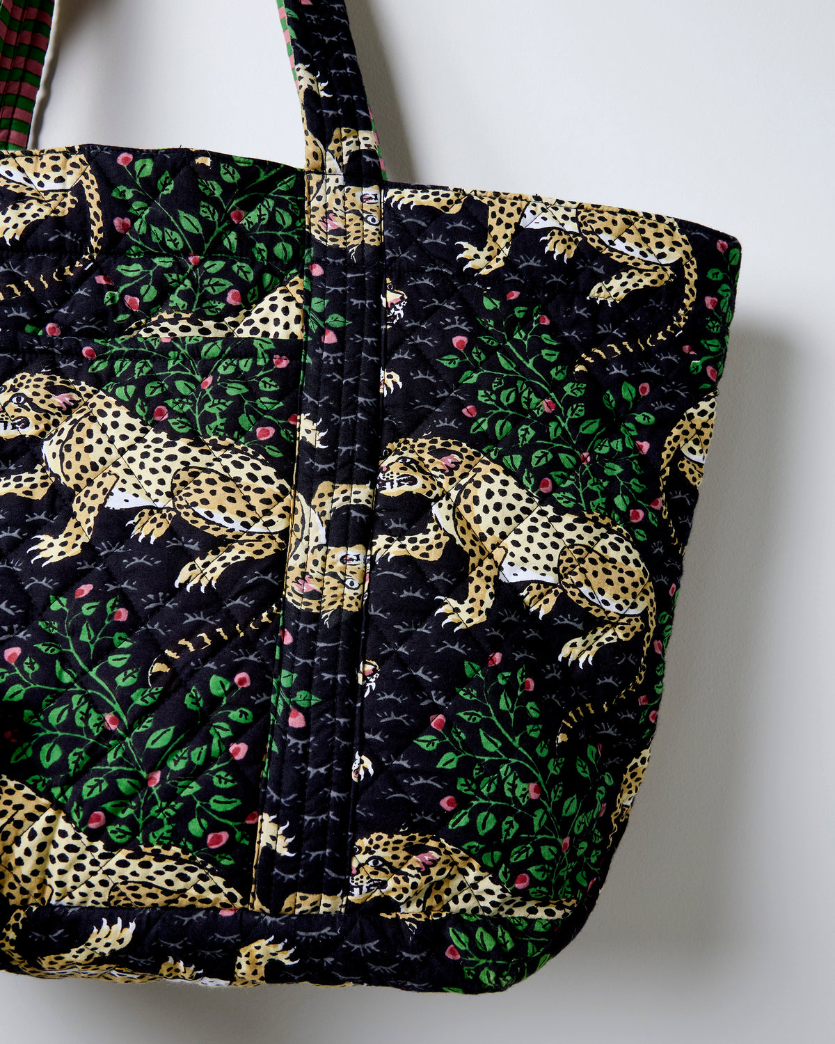 Close-up of the Ink Bagheera weekend bag showing its leopard-and-leaf print and quilted stitching.