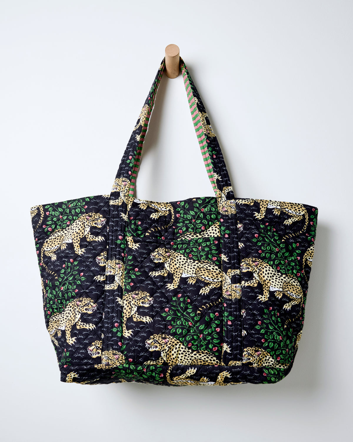 Front view of the Ink Bagheera quilted weekend bag with leopard-and-leaf print and shoulder straps.