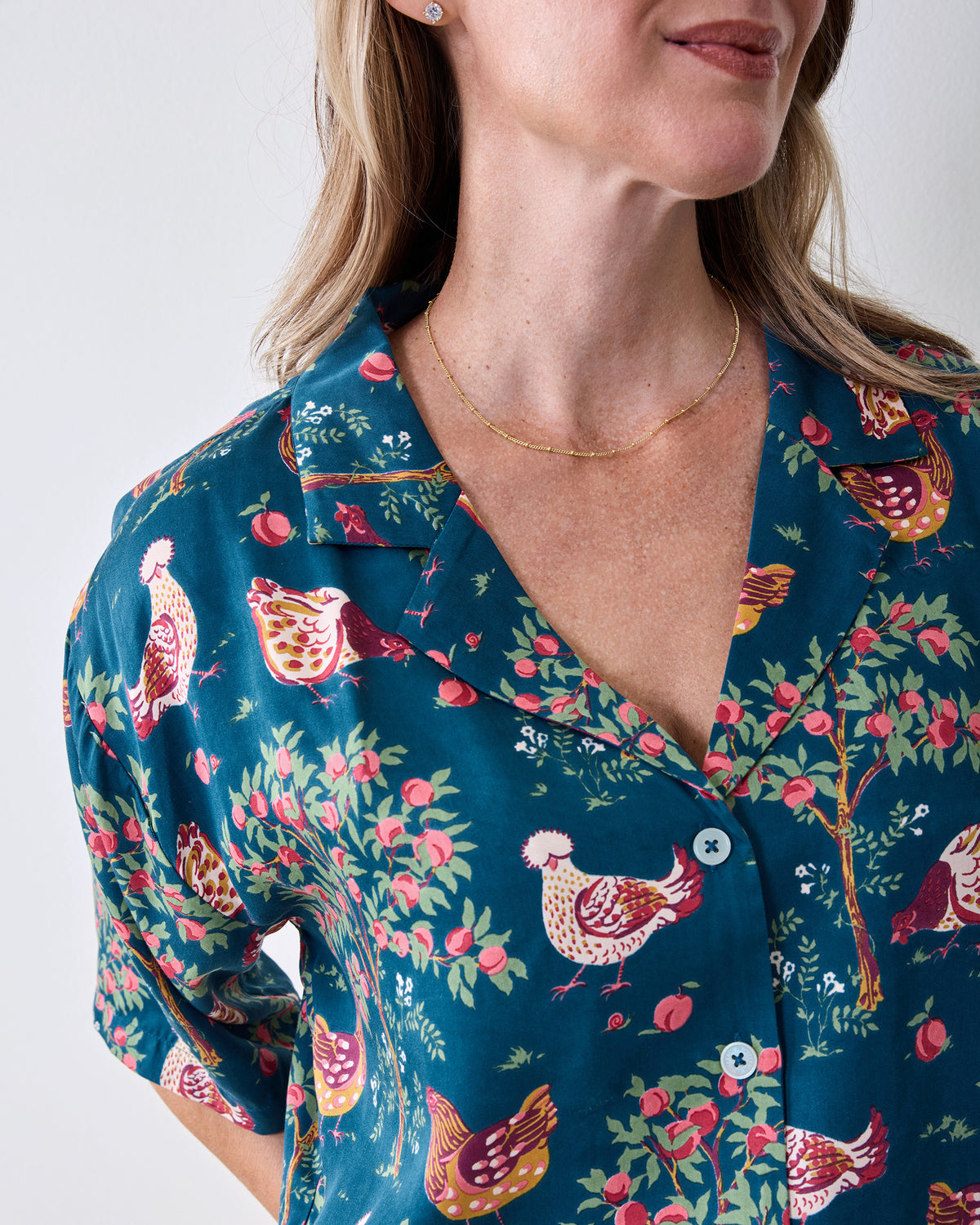 Close-up of the navy Hen House pajama top with a button front and chicken-and-fruit print.