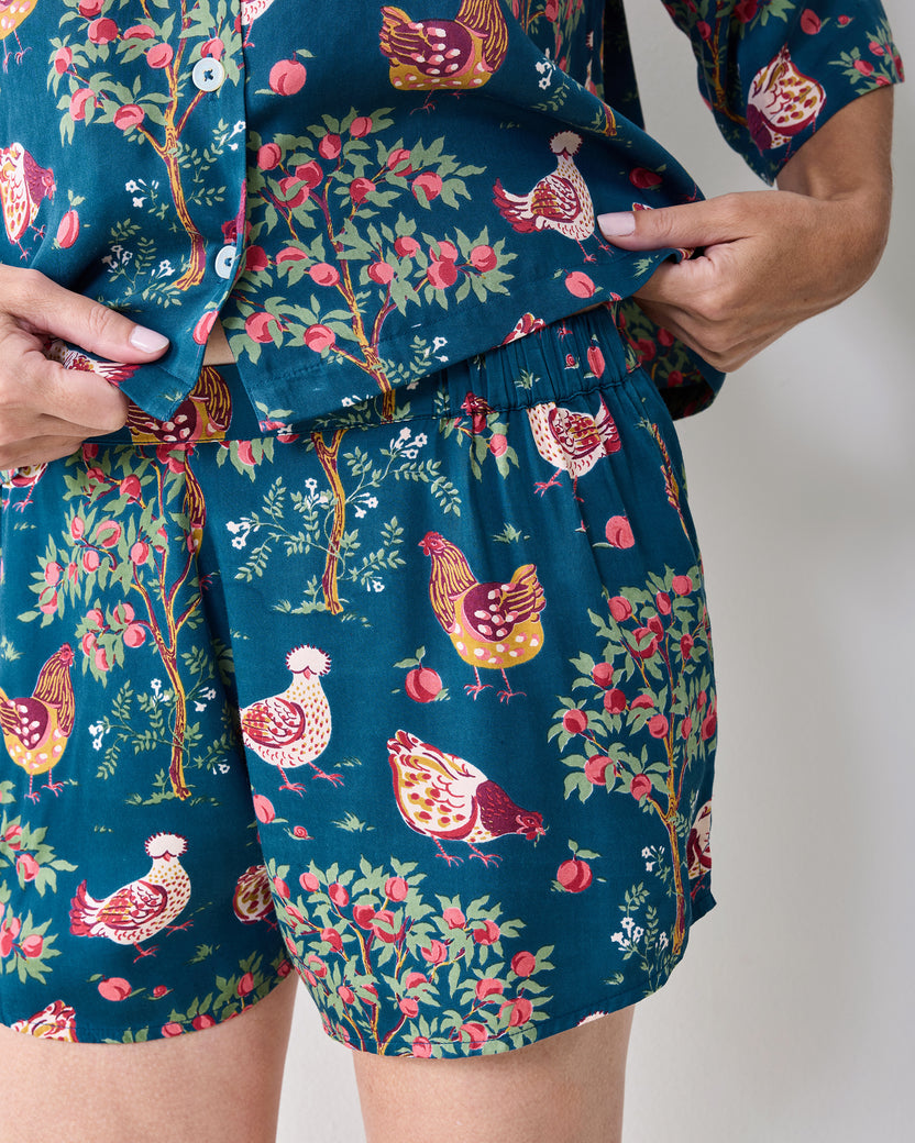 Close-up of the navy Hen House pajama shorts and top with an elastic waistband and chicken-and-fruit print.