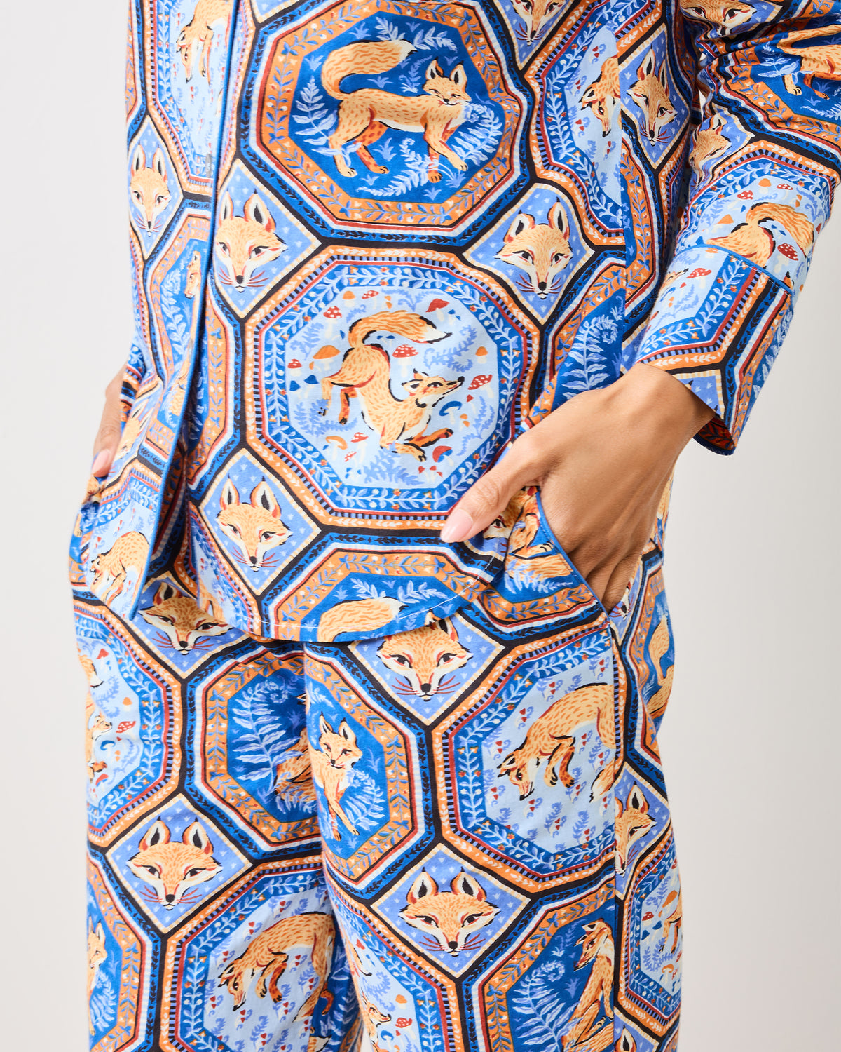 Close-up of the blue pajama set showing fox illustrations, geometric borders, and a pants pocket.