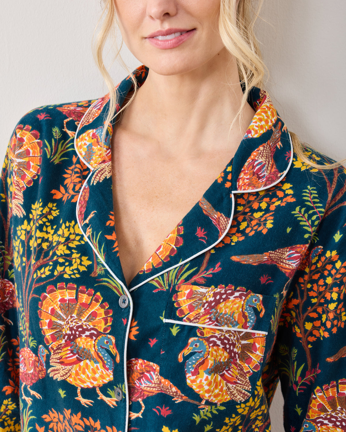 Close-up of the Turkey Trot pajama top showing its piped collar, buttons, chest pocket, and turkey print.