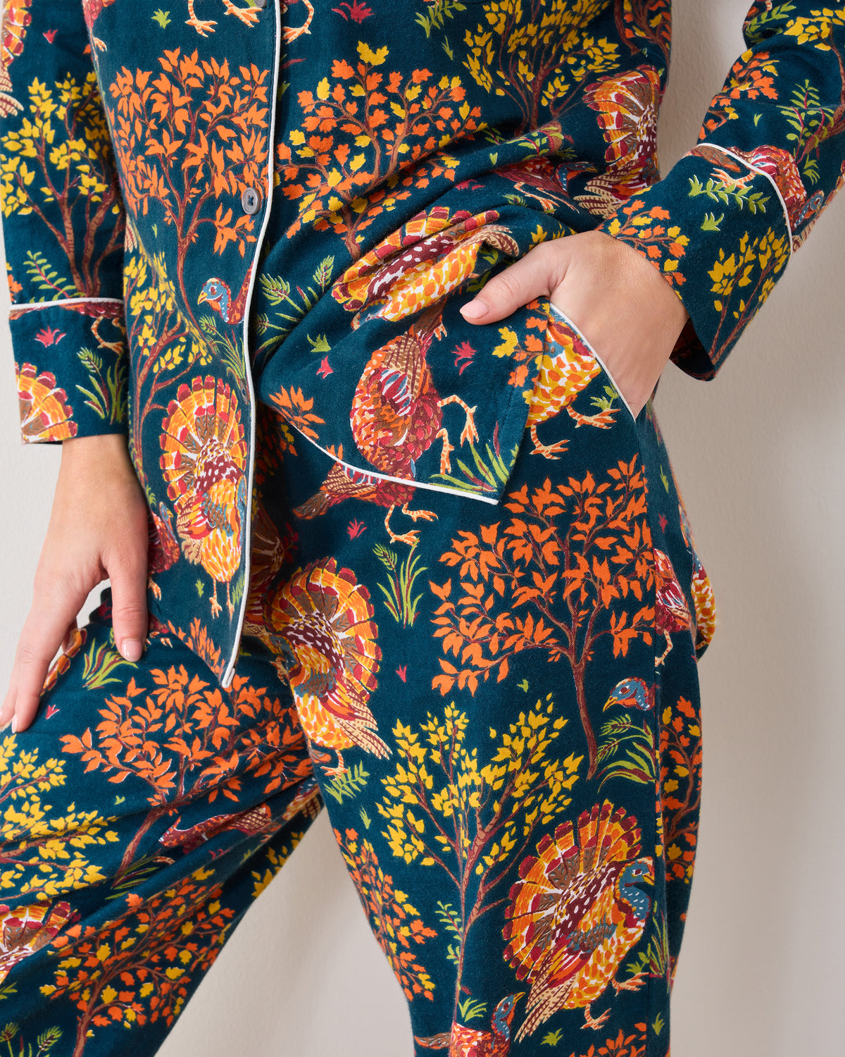 Close-up of the Turkey Trot navy pajama set showing the patterned button-down top, pocket, and pants.