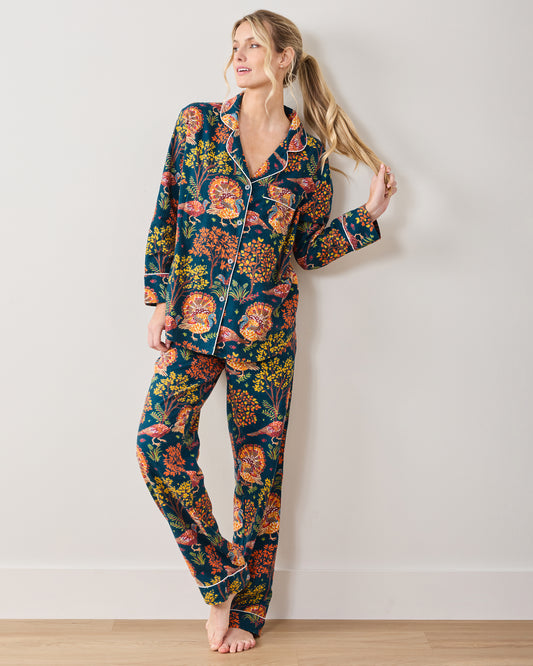 Front view of a model wearing the Turkey Trot navy long-sleeve pajama set with white piping and an autumn turkey print.