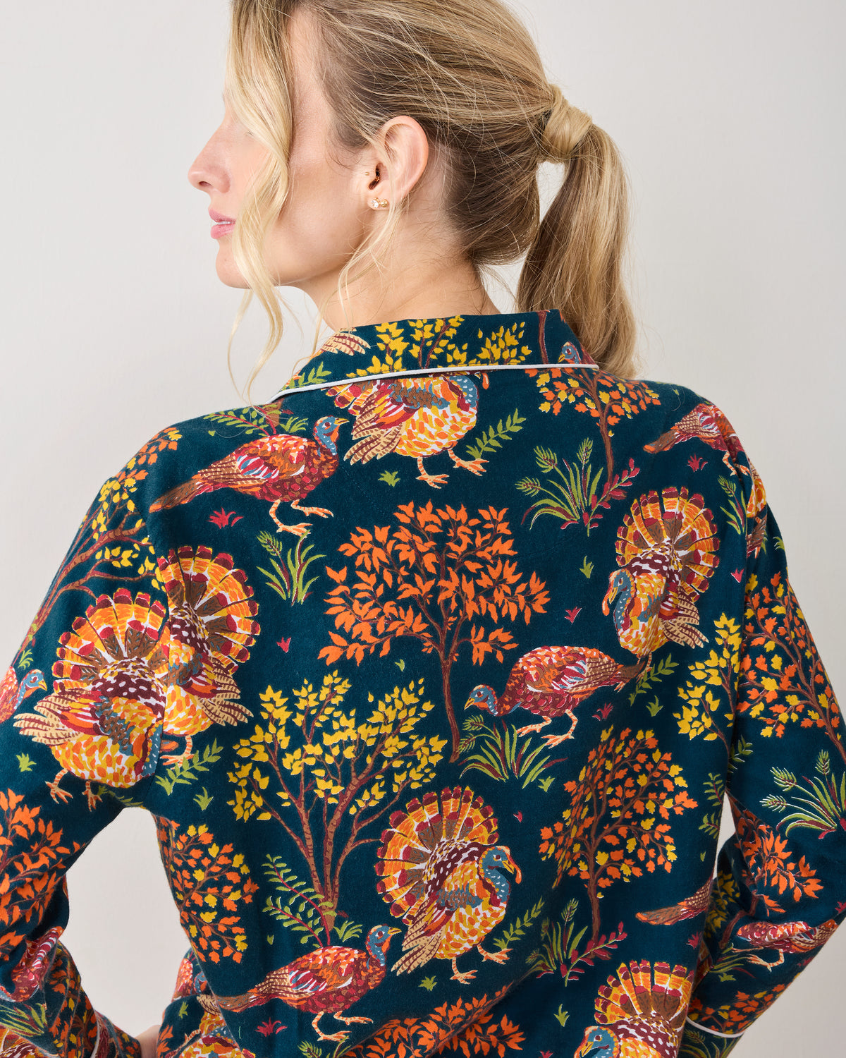Close back view of the Turkey Trot navy pajama top, showing its collar, piping, and autumn turkey and foliage print.