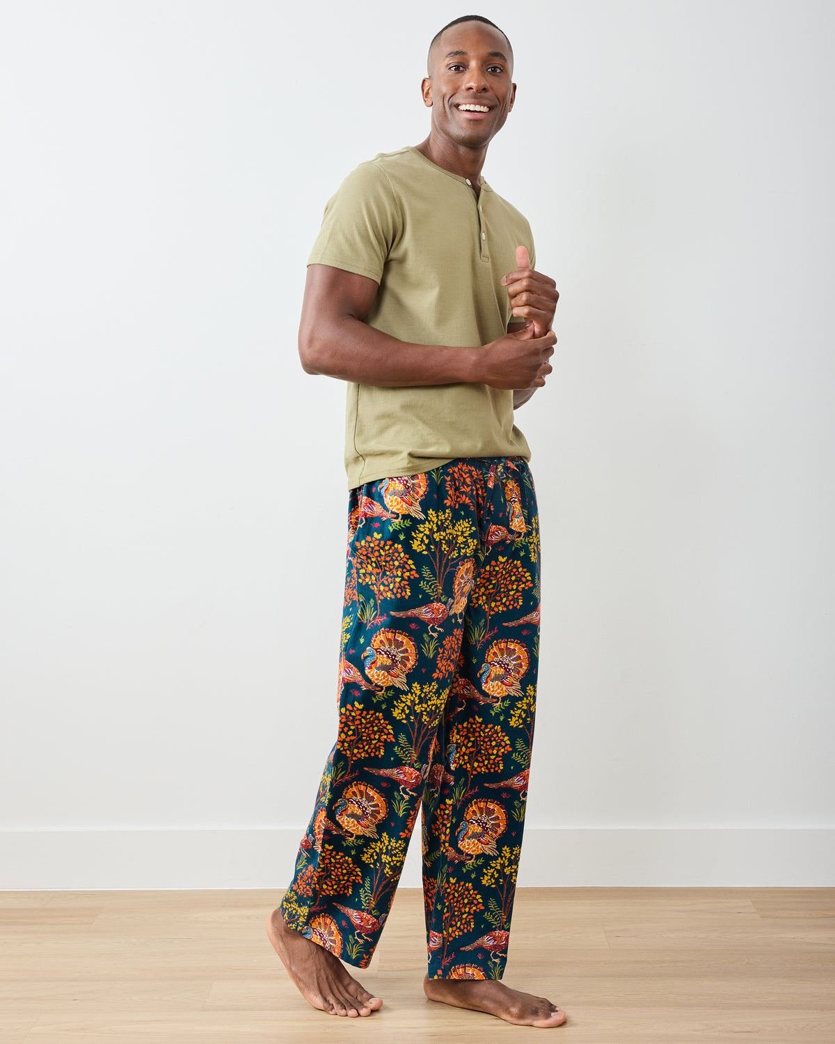 Side view of the navy Turkey Trot long pajama pants with colorful turkey and autumn foliage print.