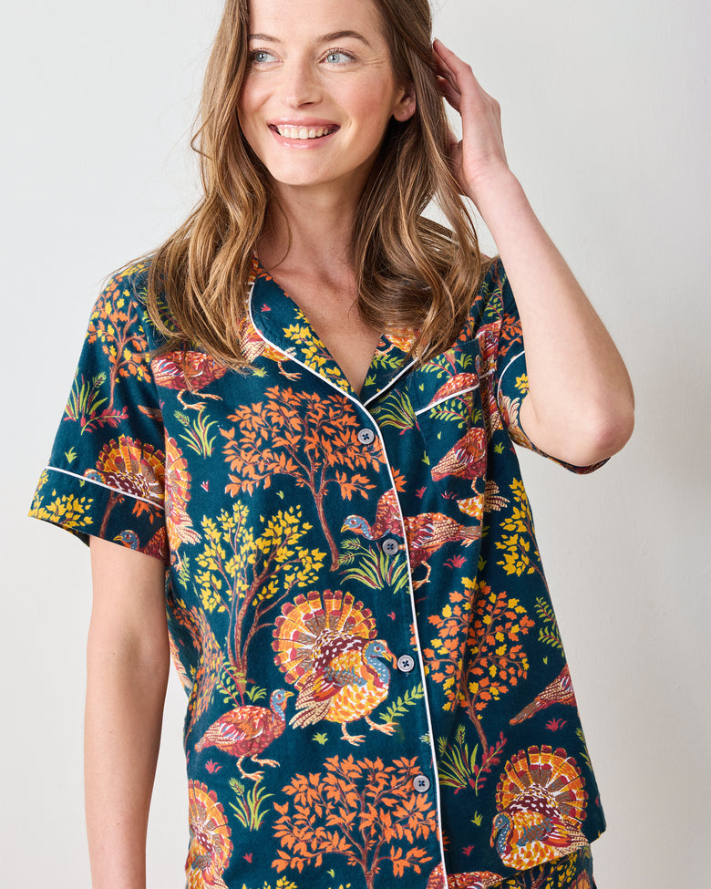Close-up front view of the navy pajama top showing the turkey and foliage print, collar, piping, and buttons.