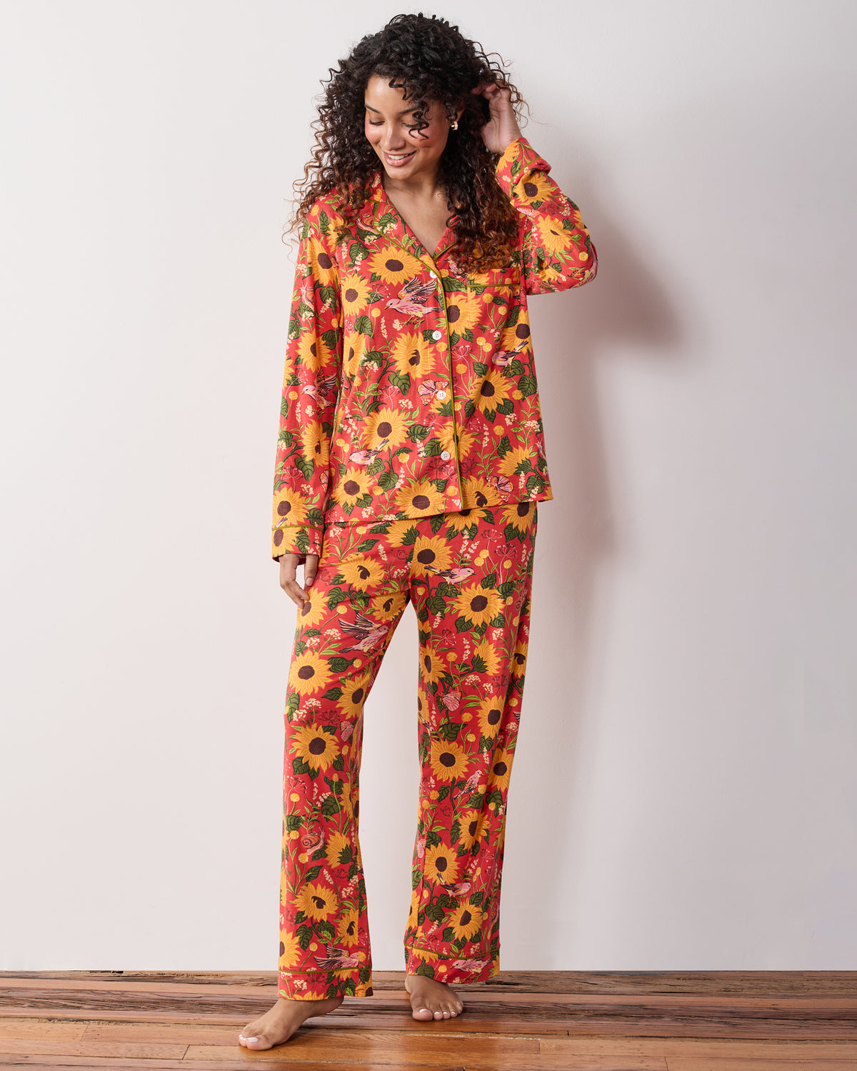 Full-length view of a person wearing the orange Autumn Sunflowers long pajama set with a button-front top and matching pants.
