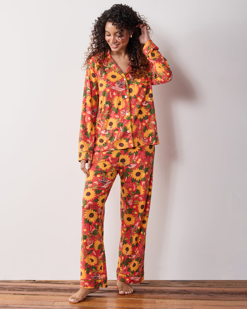 Full-length view of a person wearing the orange Autumn Sunflowers long pajama set with a button-front top and matching pants.