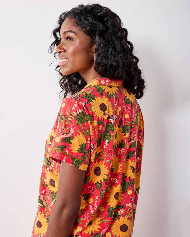 Close side and back view of the orange floral pajama top, showing its collared neckline, short sleeve, and print.