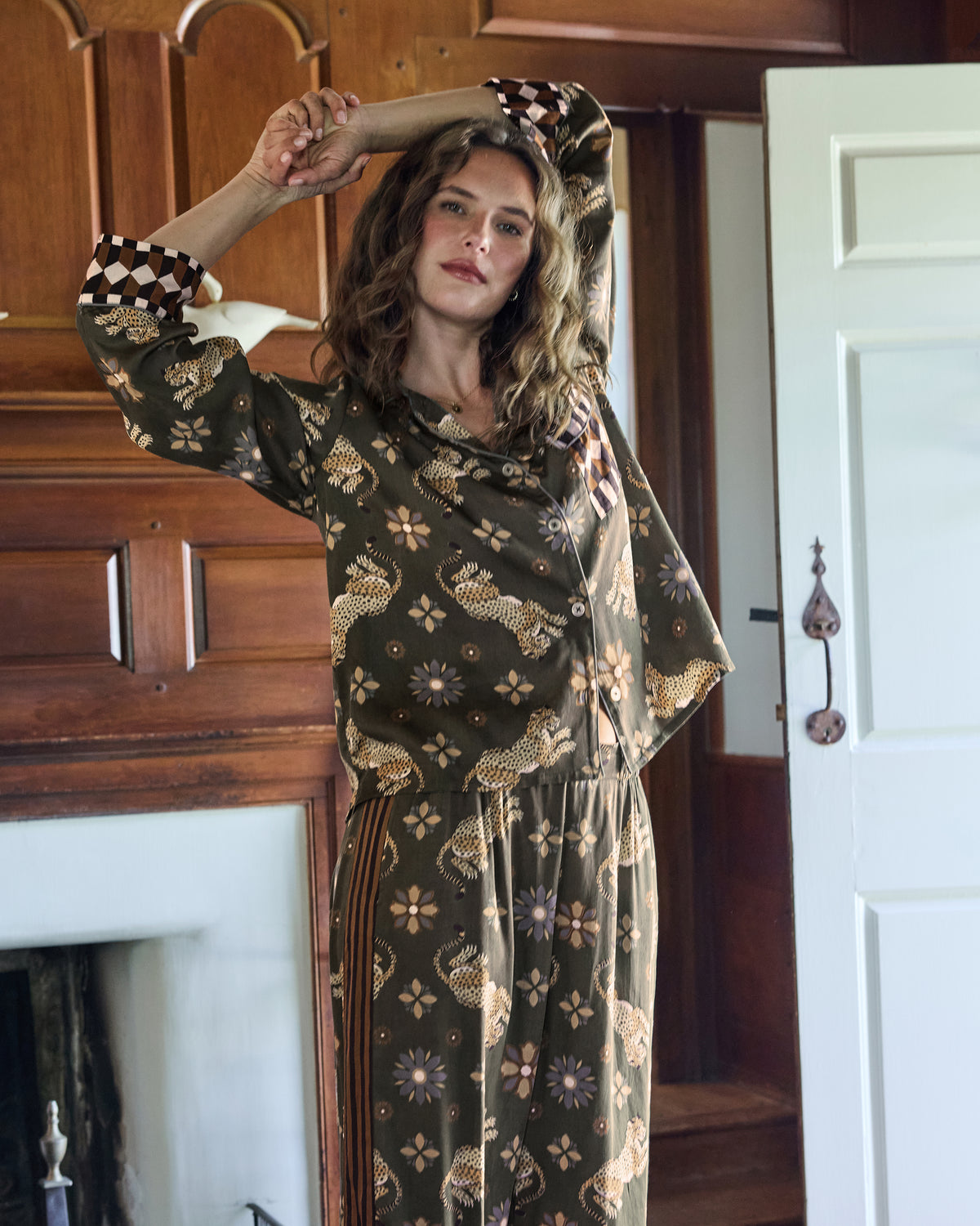Closer view of the olive leopard-and-flower pajama set, showing the long-sleeve top, checkerboard cuffs, and matching pants.