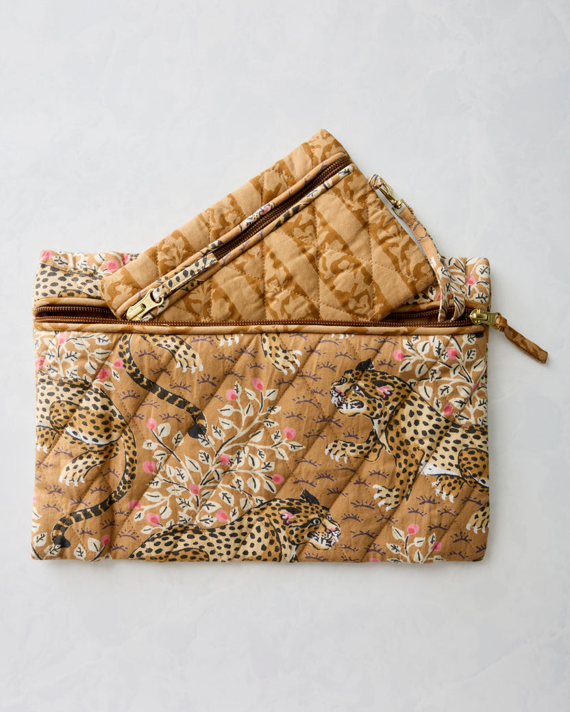 Two quilted zippered pouches in brown and tan prints, one open and layered above the other.