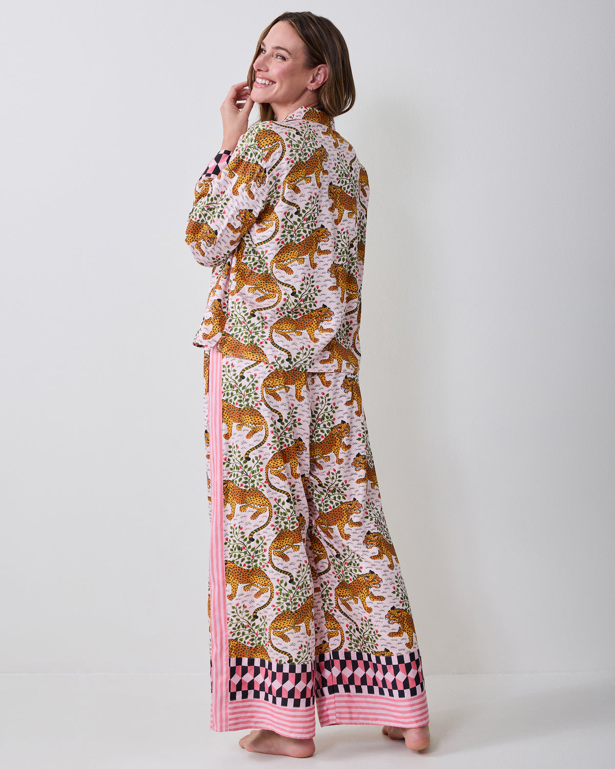 Back three-quarter view of the Bagheera blush pajama set on a model, showing the printed top and wide-leg pants with contrasting hem trim.