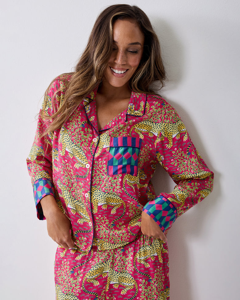 Three-quarter front view of the hot pink Bagheera pajama set with leopard-and-vine print and contrasting geometric cuffs.