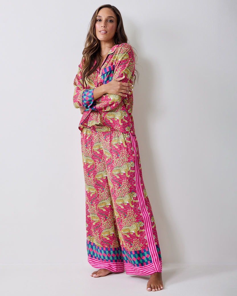 Full-length three-quarter view of the hot pink Bagheera pajama set with leopard-and-vine print, wide-leg pants, striped trim, and contrasting cuffs.
